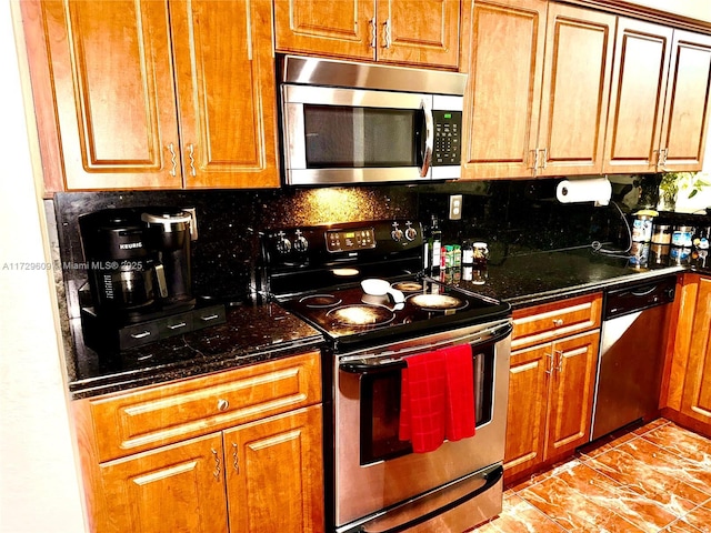 kitchen with appliances with stainless steel finishes, decorative backsplash, and dark stone counters