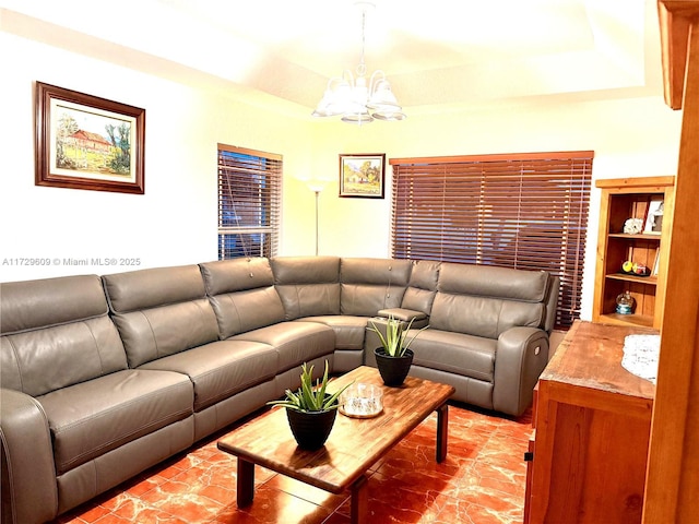 living room featuring a tray ceiling and a chandelier