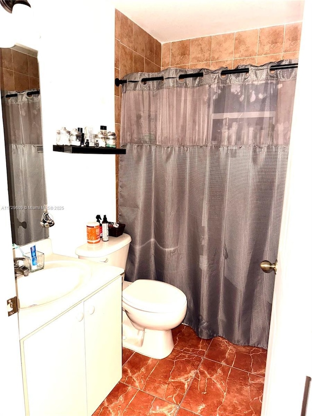 bathroom with vanity, curtained shower, and toilet