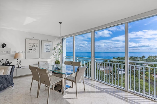 dining area with a water view, plenty of natural light, and expansive windows