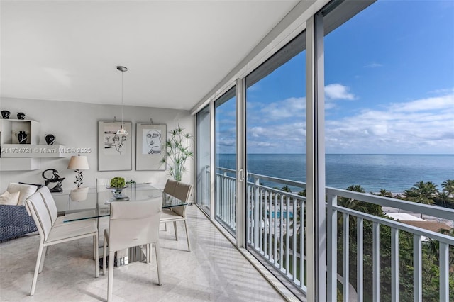 sunroom featuring a water view and a healthy amount of sunlight