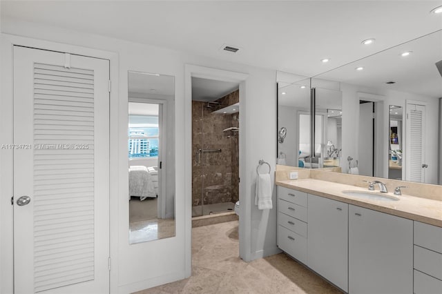 bathroom with tiled shower, vanity, and toilet