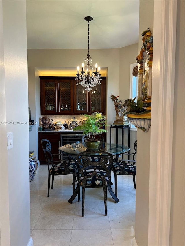 tiled dining space featuring wine cooler and a notable chandelier