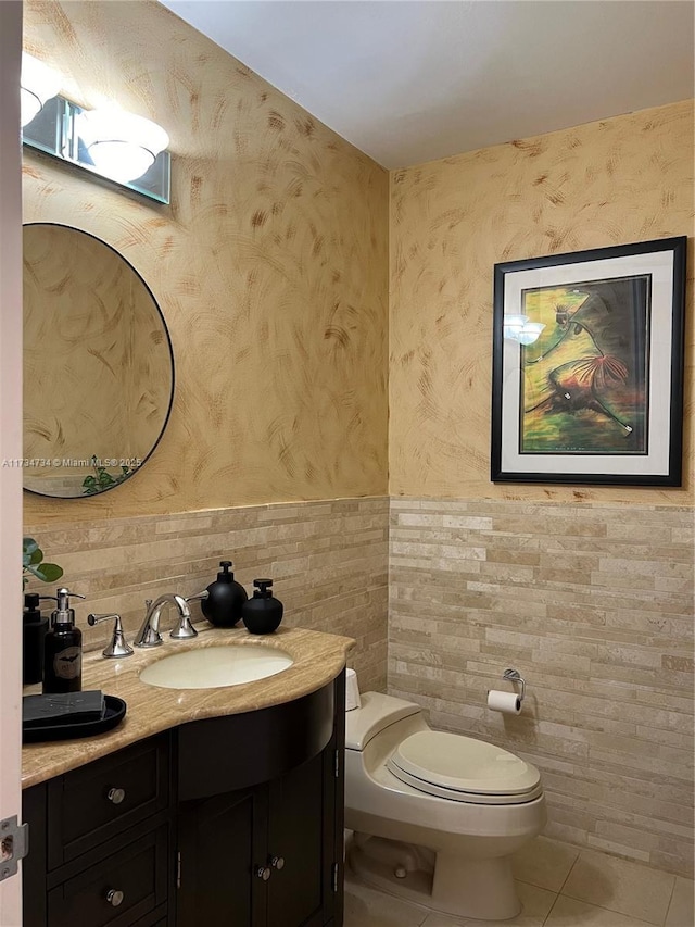 bathroom featuring tile patterned flooring, vanity, tile walls, and toilet