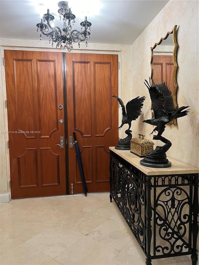 tiled foyer entrance with a chandelier