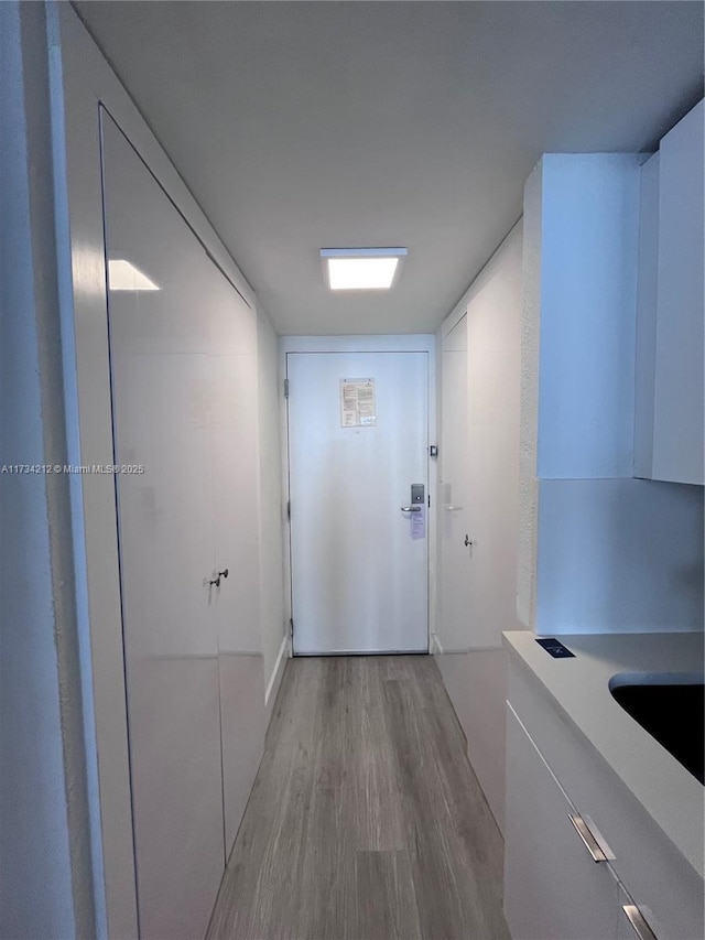 hallway featuring sink and light hardwood / wood-style floors