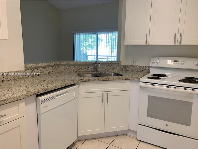 kitchen with white cabinetry, sink, light stone counters, and white appliances