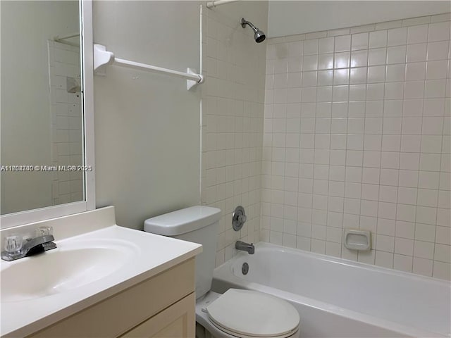 full bathroom featuring tiled shower / bath, vanity, and toilet