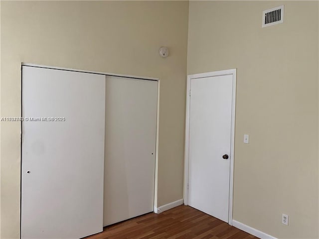 unfurnished bedroom with hardwood / wood-style flooring and a closet