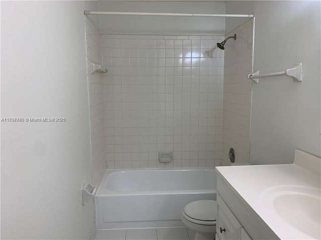 full bathroom with tile patterned flooring, vanity, tiled shower / bath, and toilet