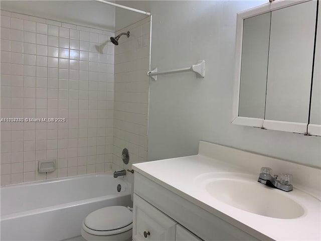 full bathroom with vanity, tiled shower / bath, and toilet