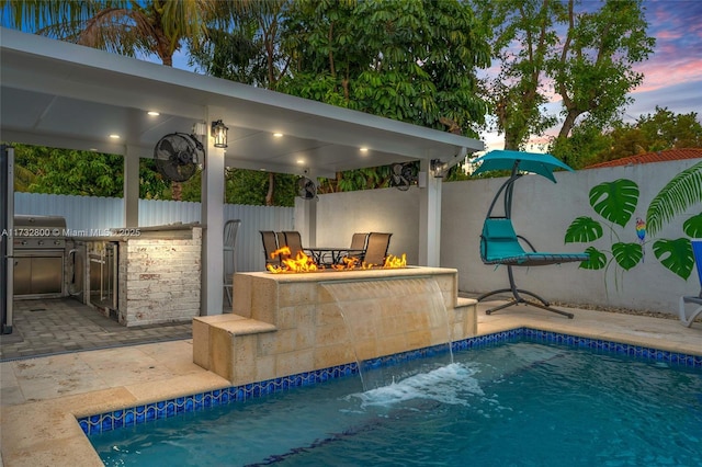 pool at dusk featuring pool water feature and a patio