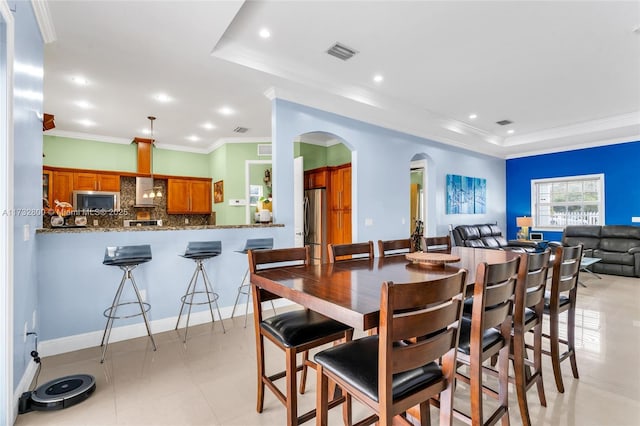 dining space with crown molding and a tray ceiling