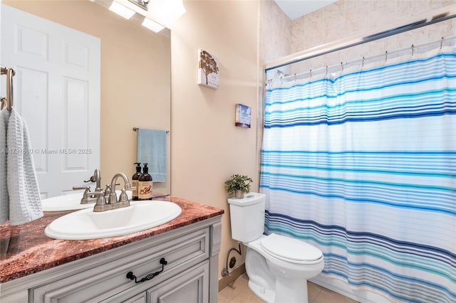 bathroom with vanity, tile patterned floors, toilet, and walk in shower