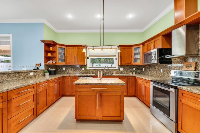 kitchen with light stone counters, appliances with stainless steel finishes, hanging light fixtures, and a center island with sink