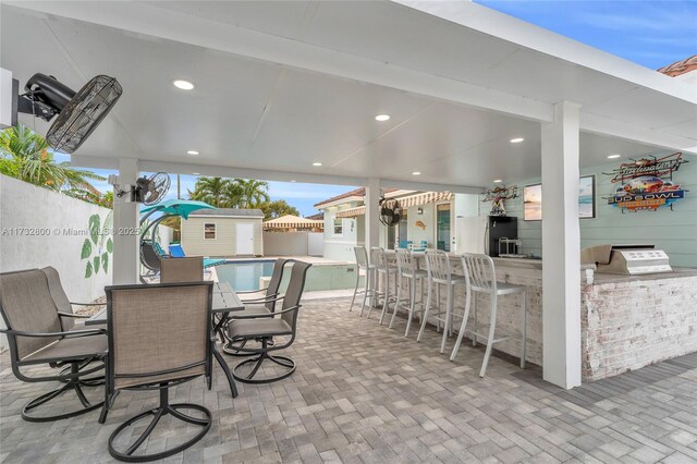 view of swimming pool with exterior kitchen and a patio