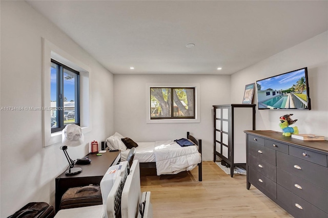 bedroom featuring multiple windows and light hardwood / wood-style floors