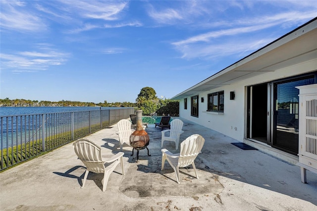 view of patio / terrace featuring a water view and a fire pit