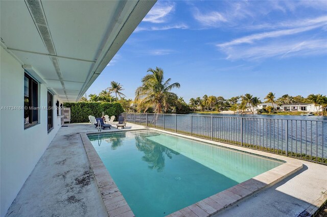 view of swimming pool featuring a patio and a water view