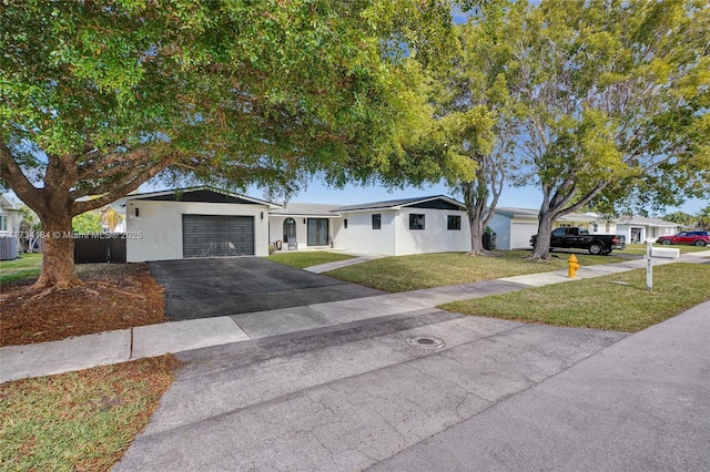 single story home with central AC unit, a garage, and a front lawn