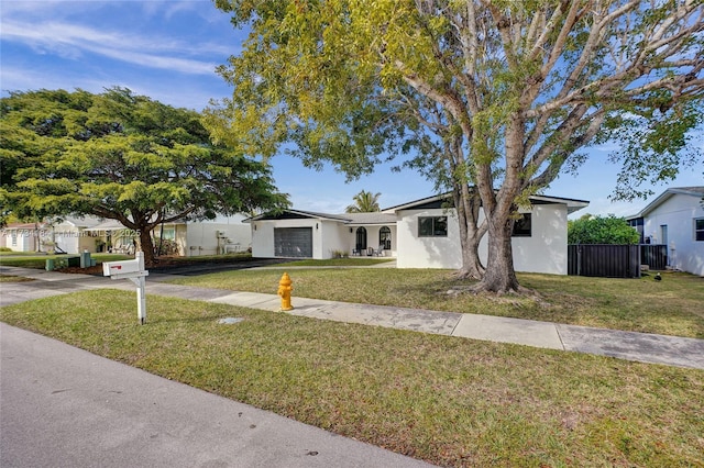 ranch-style house featuring a garage and a front lawn