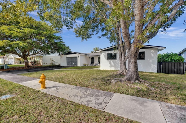 ranch-style house with a garage and a front lawn