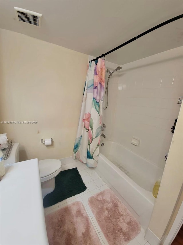 bathroom featuring tile patterned flooring, shower / tub combo, and toilet