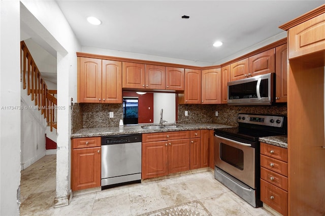 kitchen featuring backsplash, appliances with stainless steel finishes, sink, and dark stone counters