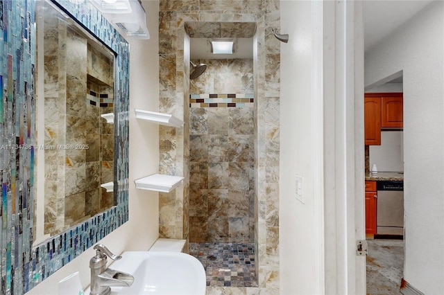 bathroom with tiled shower and sink