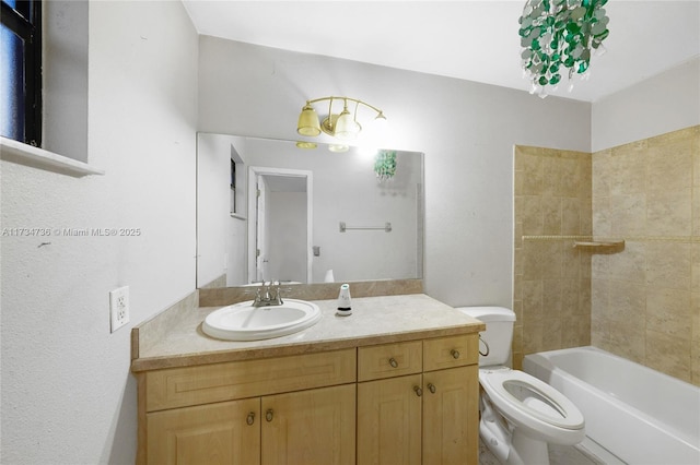 full bathroom featuring vanity, tiled shower / bath, and toilet