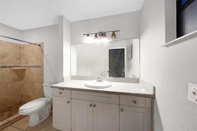 bathroom featuring vanity, toilet, and a tile shower