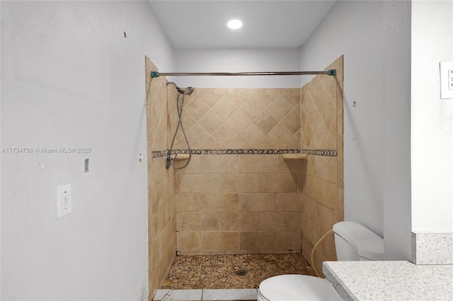 bathroom with vanity, toilet, and tiled shower