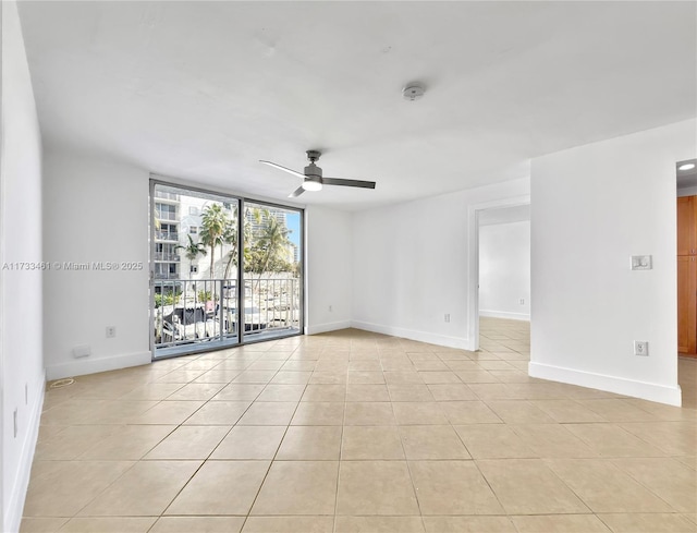 tiled empty room with expansive windows and ceiling fan