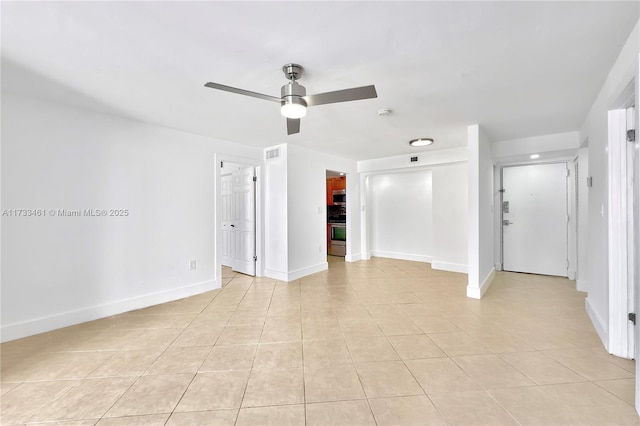 tiled empty room featuring ceiling fan