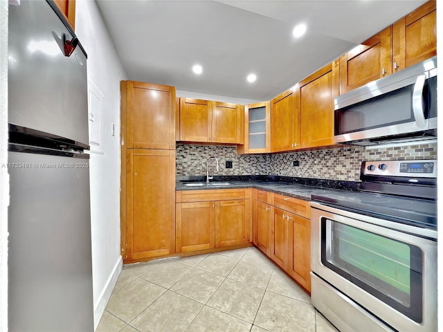 kitchen with sink, backsplash, stainless steel appliances, and light tile patterned flooring