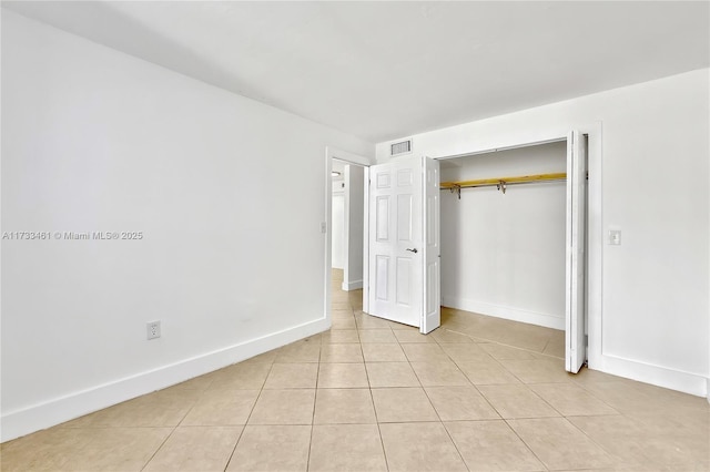 unfurnished bedroom featuring light tile patterned flooring and a closet