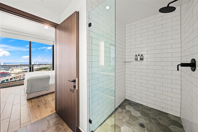 ensuite bathroom with wood finished floors, connected bathroom, and a shower stall