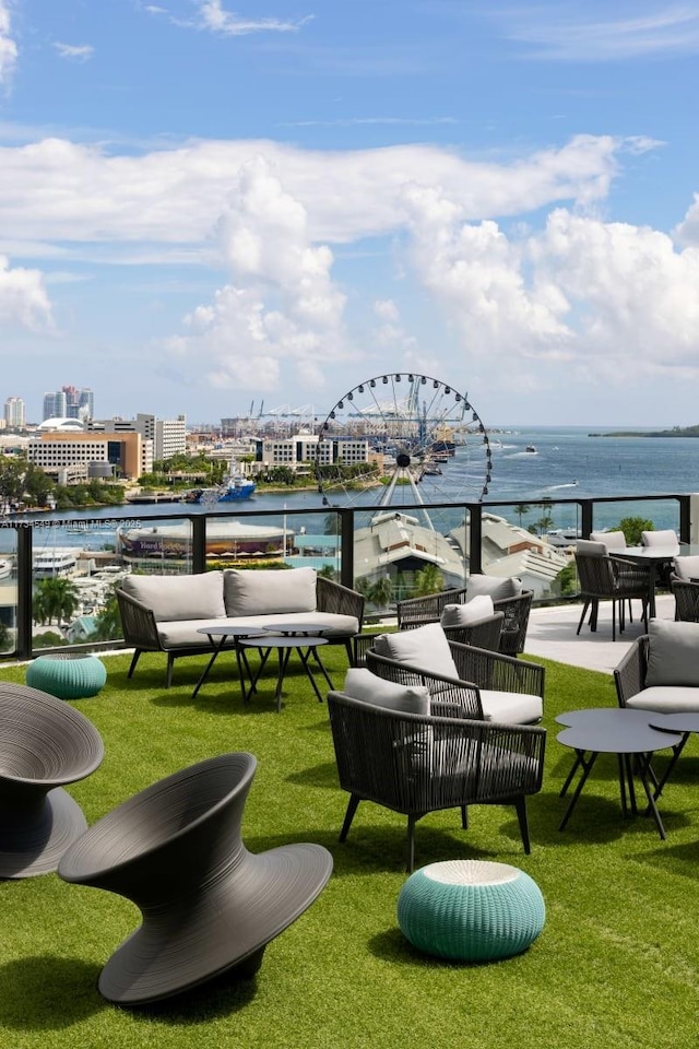 view of home's community with a yard, outdoor lounge area, and a water view