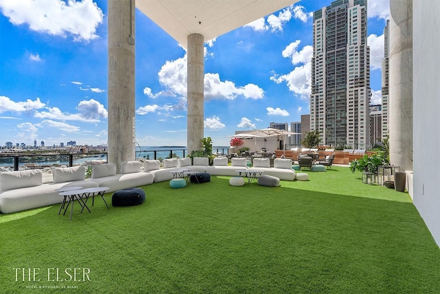 view of yard featuring a water view, an outdoor living space, and a city view