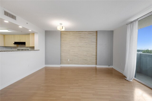 unfurnished living room with baseboards, visible vents, and light wood-style flooring