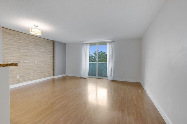 unfurnished room featuring light hardwood / wood-style flooring and a textured ceiling