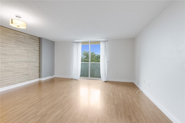 unfurnished room featuring a textured ceiling and light wood-type flooring