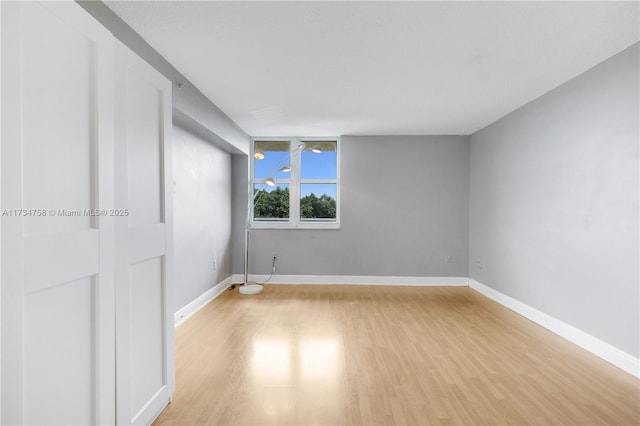 empty room featuring light wood-style floors and baseboards