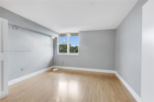 empty room featuring baseboards and wood finished floors