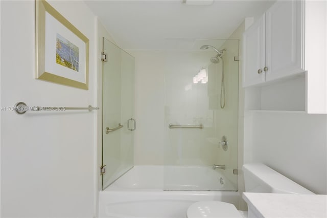 full bathroom featuring vanity, enclosed tub / shower combo, and toilet