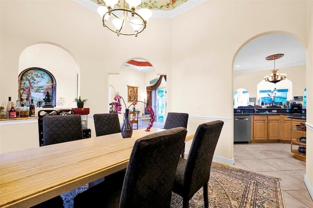 tiled dining room with a high ceiling, ornamental molding, and an inviting chandelier