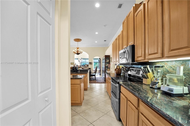 kitchen featuring pendant lighting, dark stone countertops, decorative backsplash, light tile patterned floors, and stainless steel appliances