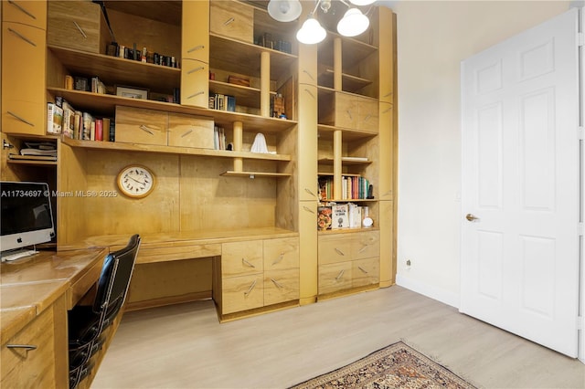 office space featuring built in desk and light wood-type flooring