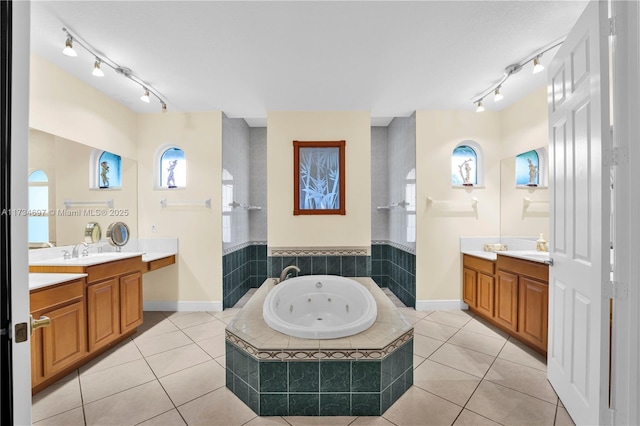 bathroom featuring tile patterned flooring, vanity, and a relaxing tiled tub