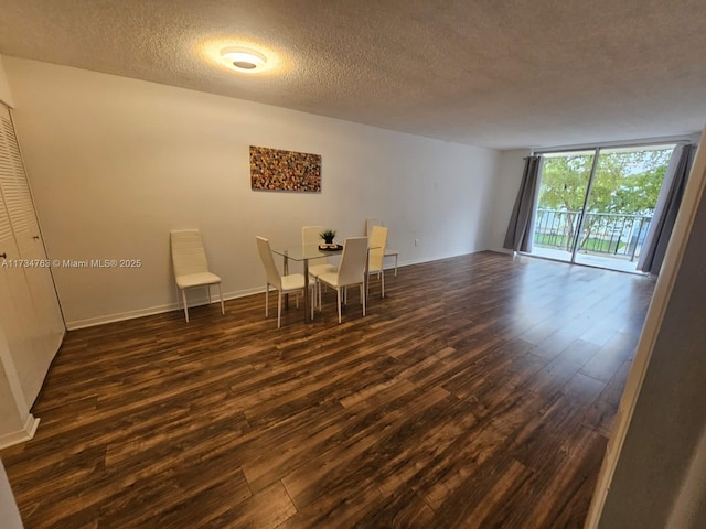 unfurnished dining area featuring floor to ceiling windows, dark hardwood / wood-style floors, and a textured ceiling